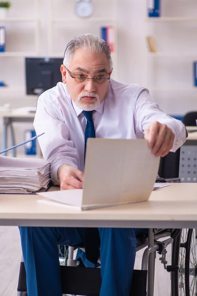 Alte männliche Angestellte im Rollstuhl sitzt im Büro — Stockfoto