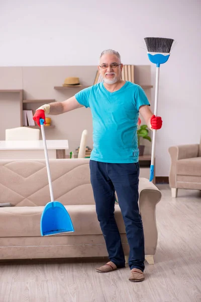 Старий прибирає будинок — стокове фото