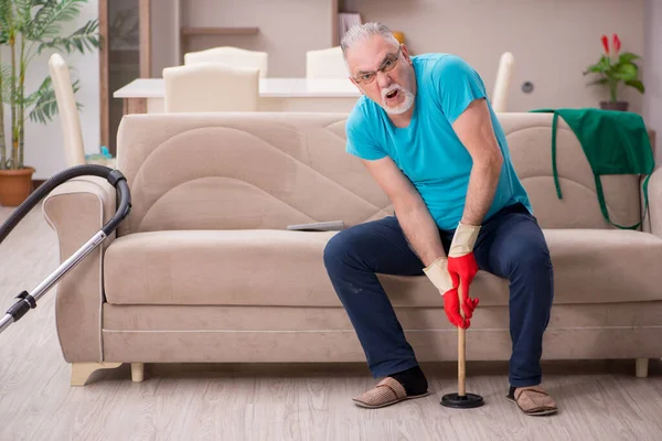 Oude man doet sanitair thuis — Stockfoto