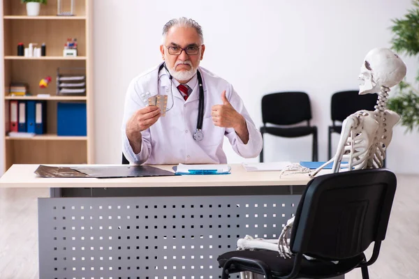 Anciano médico y paciente esqueleto en la clínica — Foto de Stock