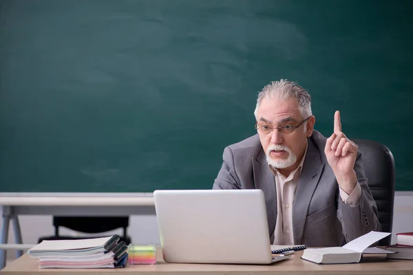 Oude mannelijke leraar voor schoolbord in telestudy concept — Stockfoto