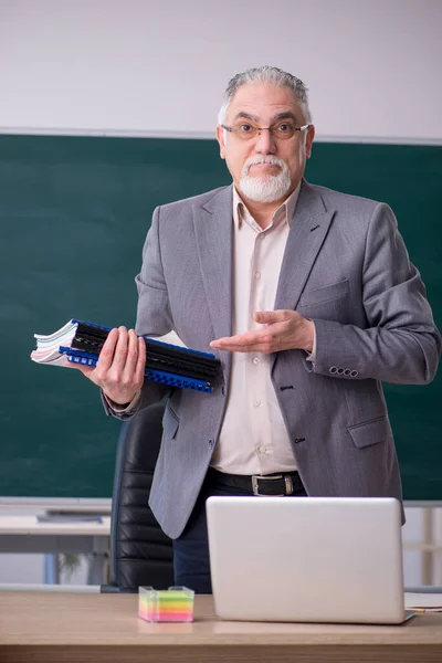 Old male teacher in front of blackboard — Stock Photo, Image