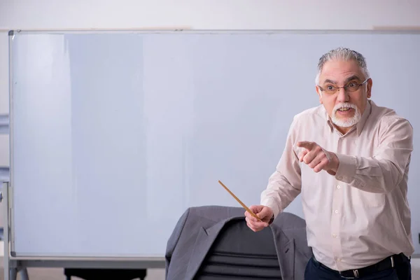 Velho professor masculino na frente do quadro branco — Fotografia de Stock