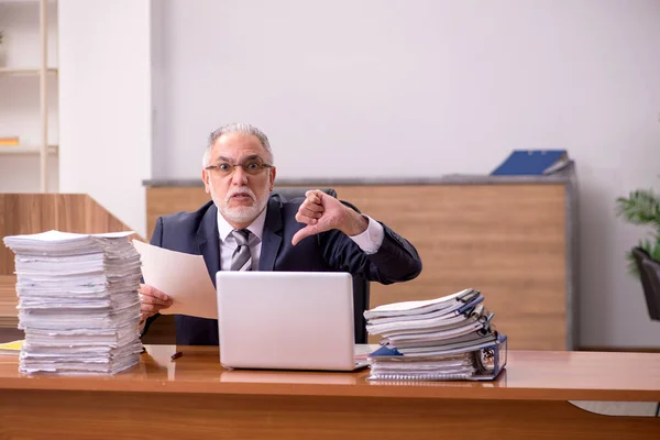 Alte männliche Angestellte und zu viel Arbeit im Büro — Stockfoto