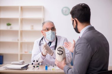 Genç işadamı aşı danışmanıyla yaşlı doktoru ziyaret ediyor.