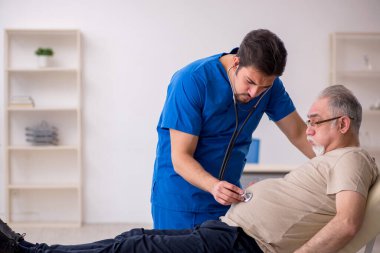 Yaşlı erkek hasta, genç doktor.