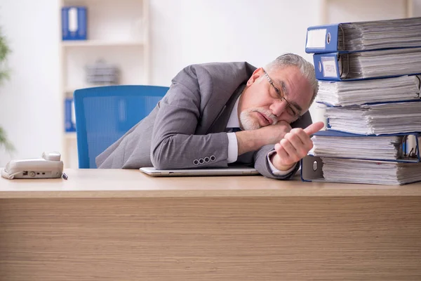 Old male employee unhappy with excessive work in the office — Stock Photo, Image