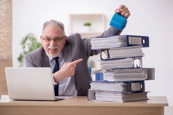 Alte männliche Angestellte unzufrieden mit exzessiver Arbeit im Büro — Stockfoto