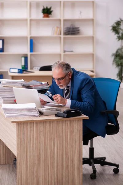 Velho empregado masculino e muito trabalho no escritório — Fotografia de Stock