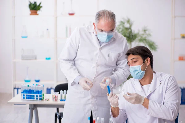 Dois químicos do sexo masculino no conceito de síntese de drogas no laboratório — Fotografia de Stock