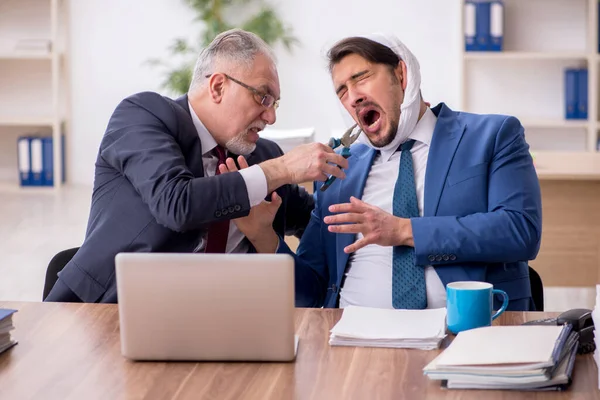 Junge männliche Angestellte leidet unter Zahnschmerzen im Büro — Stockfoto