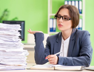 Genç bayan çalışan devam eden evrak işleriyle çok meşgul.