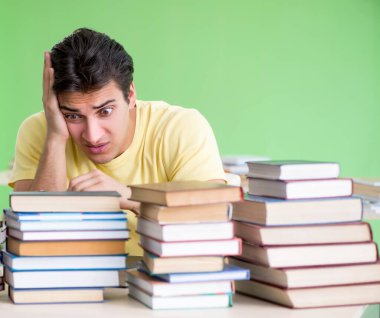 Sınavdan önce okumak için çok fazla kitabı olan öğrenci