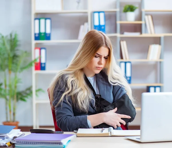 Injured female employee working in the office — Stock Photo, Image