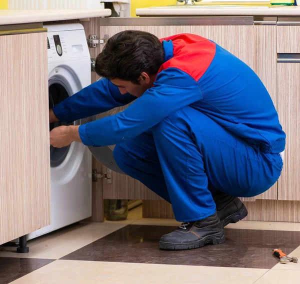 Reparateur repariert Waschmaschine in der Küche — Stockfoto