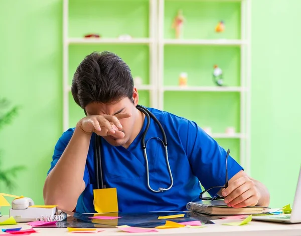 Jonge arts zit in het ziekenhuis met veel tegenstrijdige prioriteiten — Stockfoto