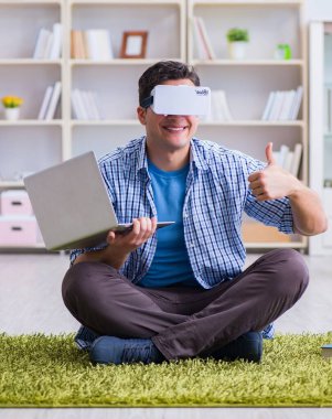 Evde sanal gerçeklik gözlükleriyle serbest çalışan bir öğrenci.