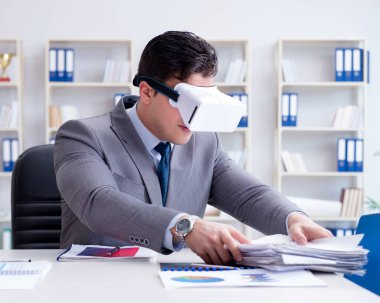 Ofiste sanal gerçeklik gözlüklü bir iş adamı var.