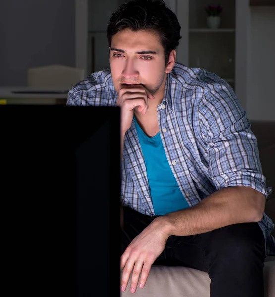 Jeune homme regardant la télévision tard dans la nuit — Photo