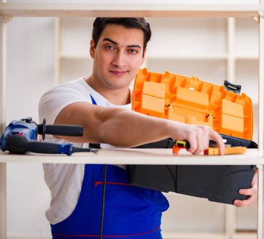 İşçi adam montaj kitaplığını tamir ediyor