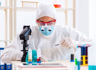 Laboratuvarda kimyasallar üzerinde çalışan genç bir kimyager.