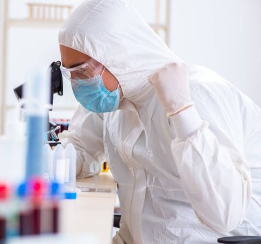 Laboratuvarda kimyasallar üzerinde çalışan genç bir kimyager.