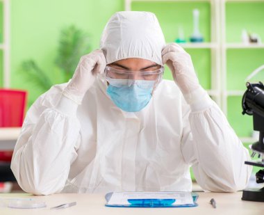 Laboratuvarda yeni bir deney üzerinde çalışan kimyager.