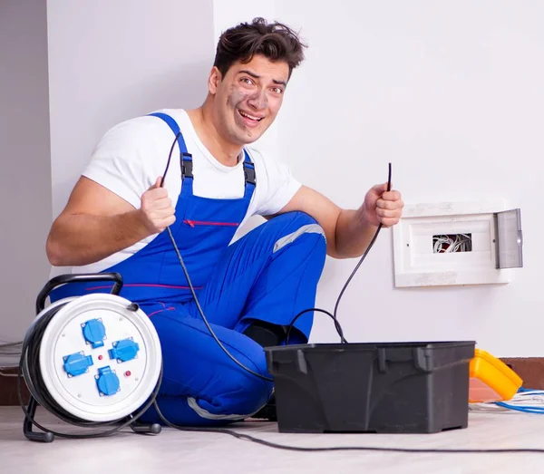Funny Man naprawia prąd w domu — Zdjęcie stockowe