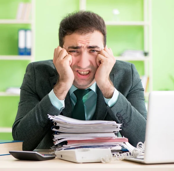 Businessman angry with excessive work sitting in the office — Stock Photo, Image