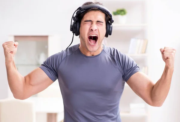 Homem fazendo esportes em casa e ouvindo música — Fotografia de Stock