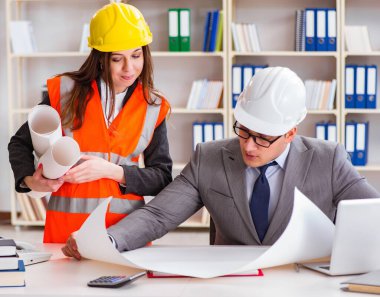 İnşaat ustabaşı çizimleri gözden geçiriyor