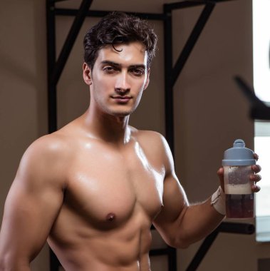 Spor salonunda besin takviyesi olan bir adam.