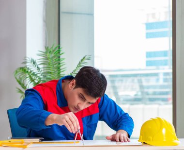 Foreman inşaat planına bakıyor.