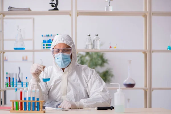Молодой химик работает в лаборатории во время пандемии — стоковое фото