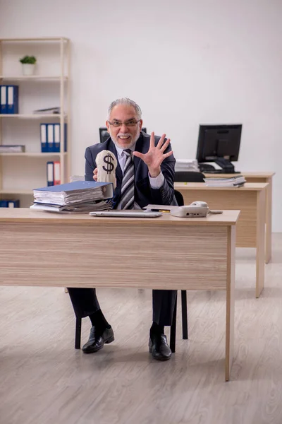 Betagter Geschäftsmann mit Geldbeutel im Büro — Stockfoto