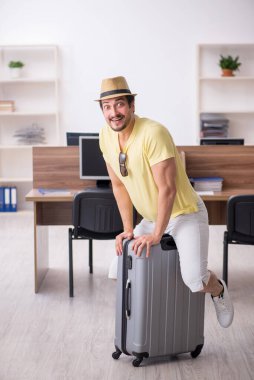 Genç bir erkek işçi iş yerinde geziye hazırlanıyor.