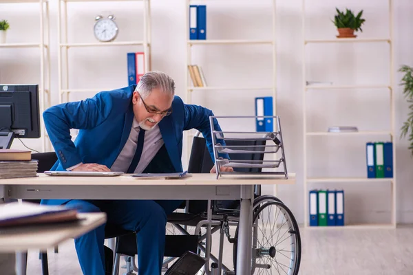 Alte männliche Angestellte im Rollstuhl sitzt im Büro — Stockfoto