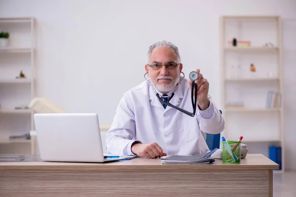 Klinikte çalışan yaşlı erkek doktor. — Stok fotoğraf