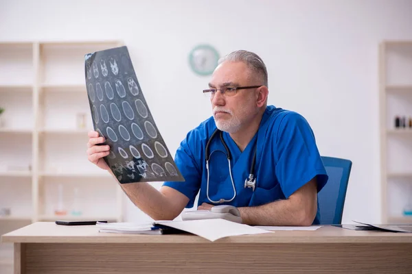 Gammal manlig röntgenläkare som arbetar på kliniken — Stockfoto