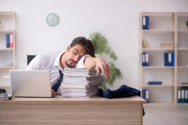 Jovem funcionário masculino infeliz com excesso de trabalho no escritório — Fotografia de Stock