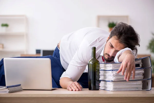 Joven adicto al alcohol empleado masculino que trabaja en la oficina — Foto de Stock