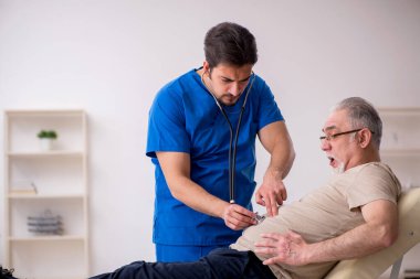 Yaşlı erkek hasta, genç doktor.