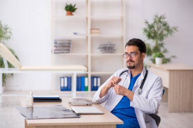 Genç erkek doktor klinikte hap öneriyor.