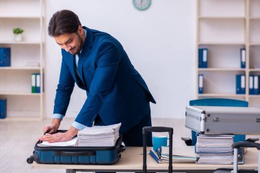 Genç erkek çalışan iş gezisine hazırlanıyor.