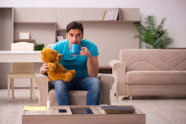 Joven sentado con oso juguete en casa —  Fotos de Stock