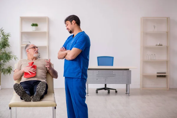 Velho paciente masculino visting jovem médico gastroenterologista masculino — Fotografia de Stock