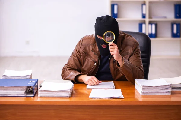 Young man in balaclava stealing information from the office — Stock Photo, Image