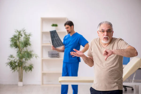 Öreg férfi beteg visting fiatal férfi orvos radilogist — Stock Fotó