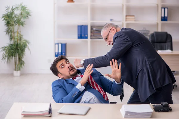 Vecchio capo e giovane dipendente maschile nel concetto di bullismo — Foto Stock