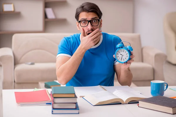 Joven estudiante masculino que estudia en casa en concepto de gestión del tiempo — Foto de Stock